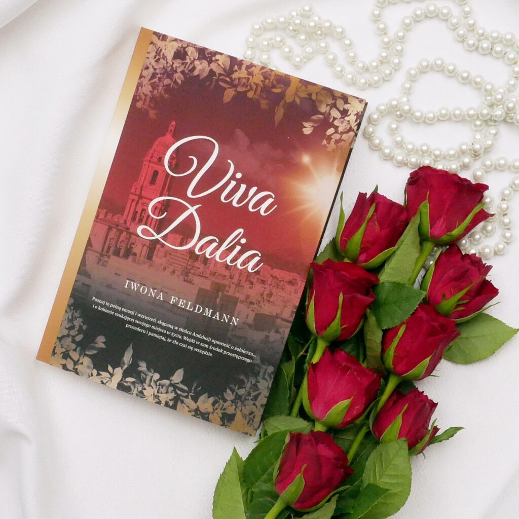 Iwona Feldman „Viva Dalia” - recenzja Okładka książki „Viva Dalia” autorstwa Iwony Feldman leżąca na białym materiale w otoczeniu czerwonych róż i pereł.