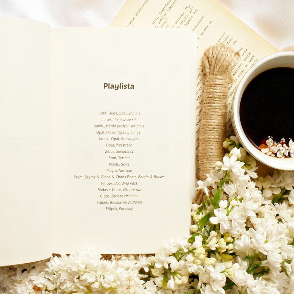 Playlista z książki „Romans pod siatką” Strona z playlistą w książce „Romans pod siatką” Agaty Sobczak i K. Hellishdeer