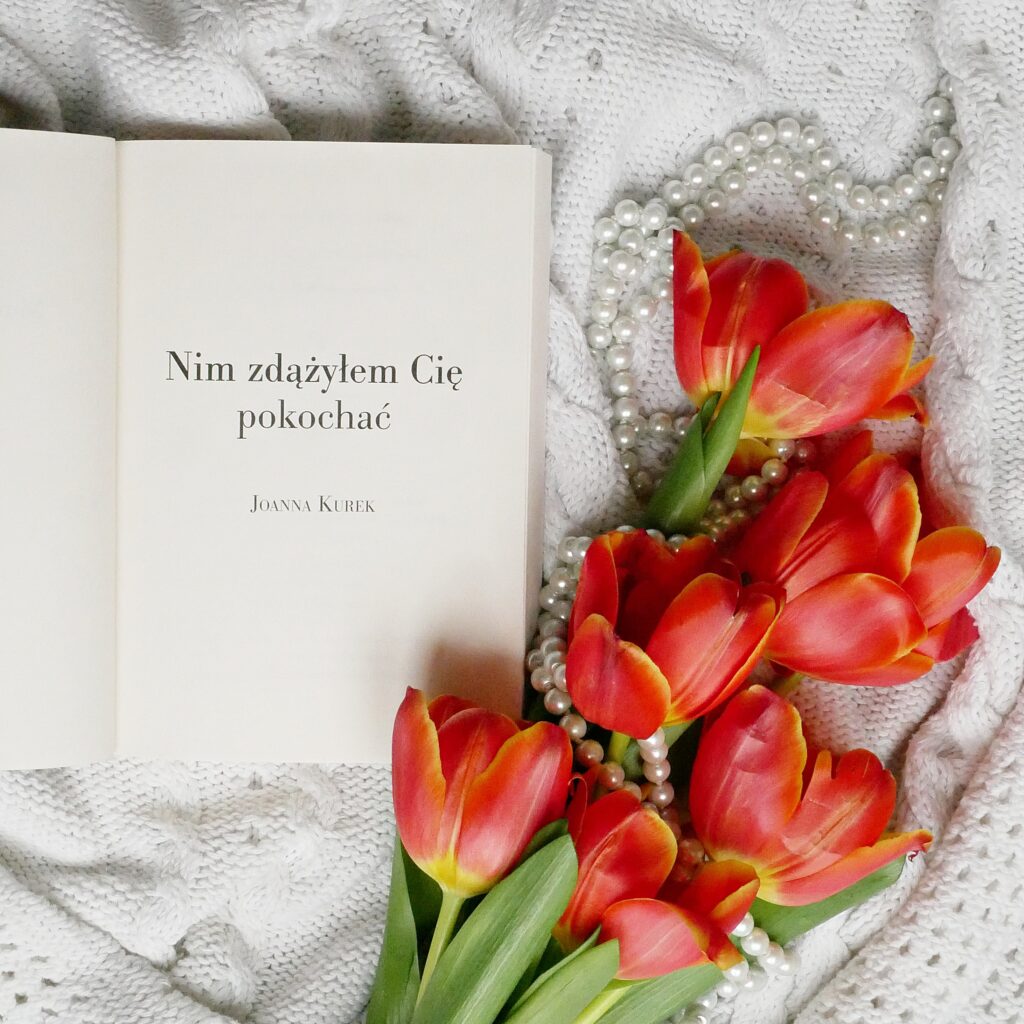 Strona tytułowa książki „Nim zdążyłem Cię pokochać” autorstwa Joanny Kurek Strona tytułowa książki „Nim zdążyłem Cię pokochać” autorstwa Joanny Kurek. Obok leżą perły i tulipany.