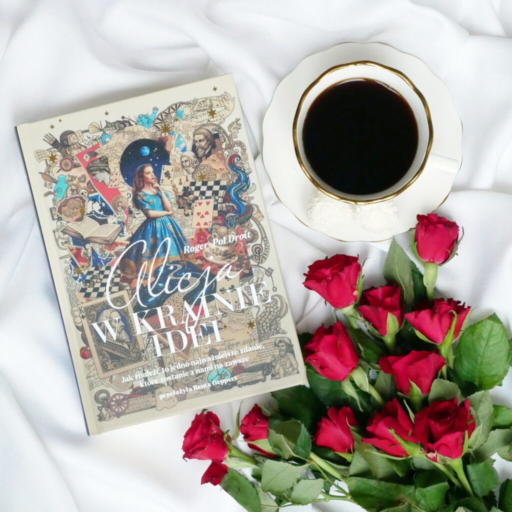 Okładka książki „Alicja w Krainie Idei” autorstwa Rogera-Pola Droita leżąca na białym materiale obok filiżanki czarnej kawy i czerwonych róż.