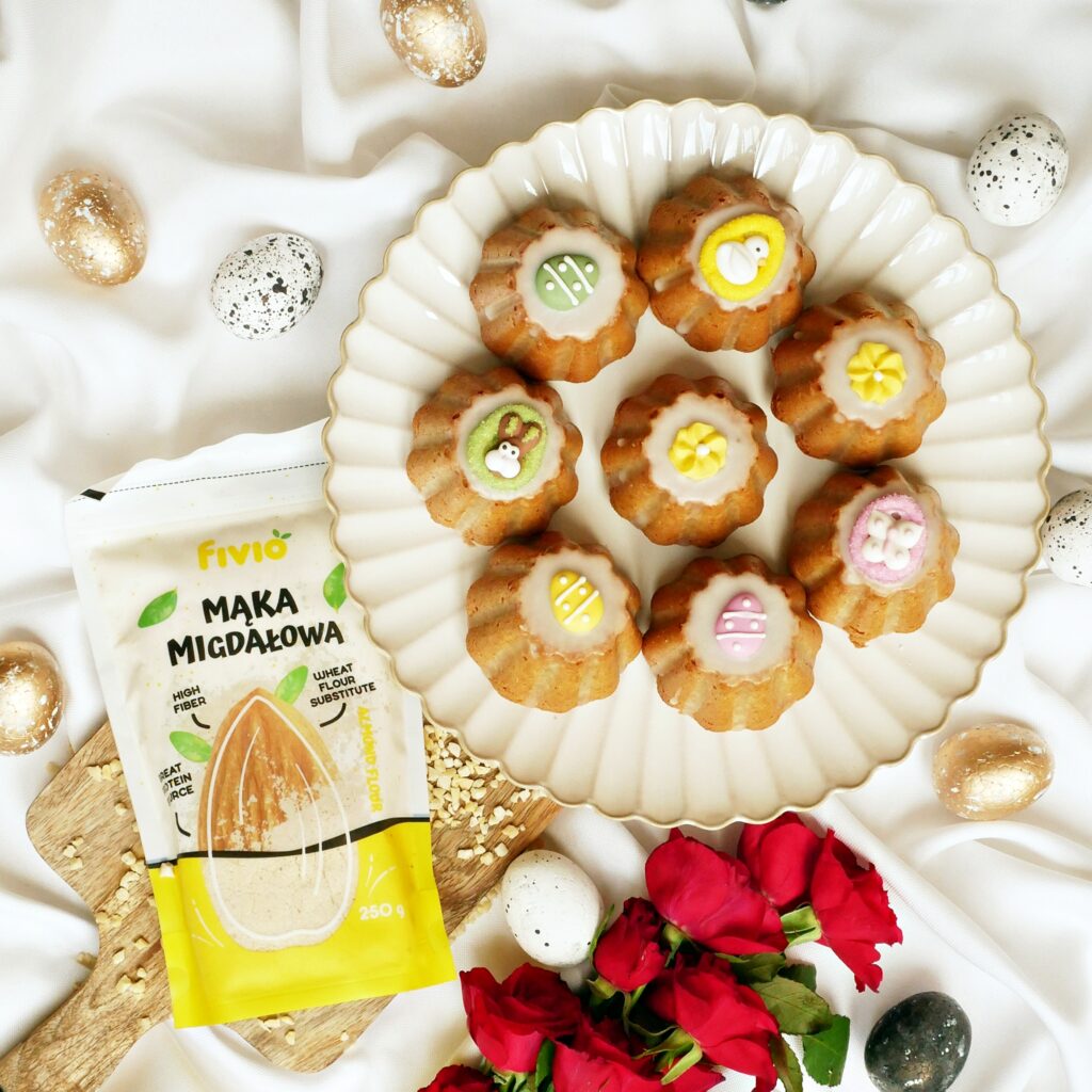 Wielkanocne babeczki migdałowe z mąka Fivio i czerwone róże w aranżacji flat lay.
