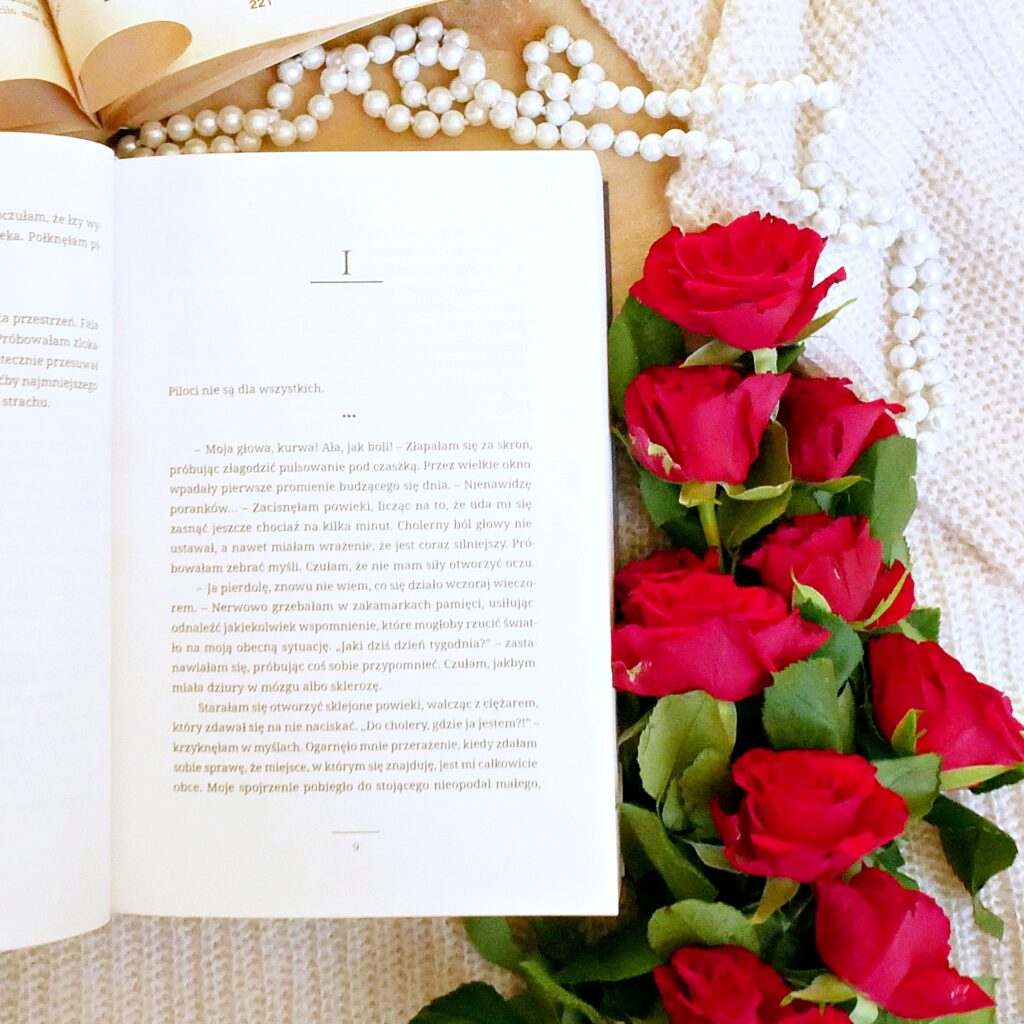 Wnętrze książki „Soulmate” Anny I. Hains - Rozdział 1 Rozdział 1 książki „Soulmate” w otoczeniu czerwonych róż, pereł i starej książki.