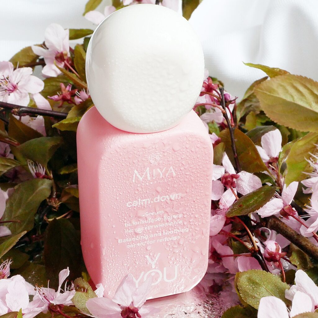 Serum balansująco-kojące na zaczerwienienia calm.down Miya Cosmetics Y.YOU Serum balansująco-kojące na zaczerwienienia calm.down Miya Cosmetics Y.YOU. Dookoła różowe wiosenne kwiaty.