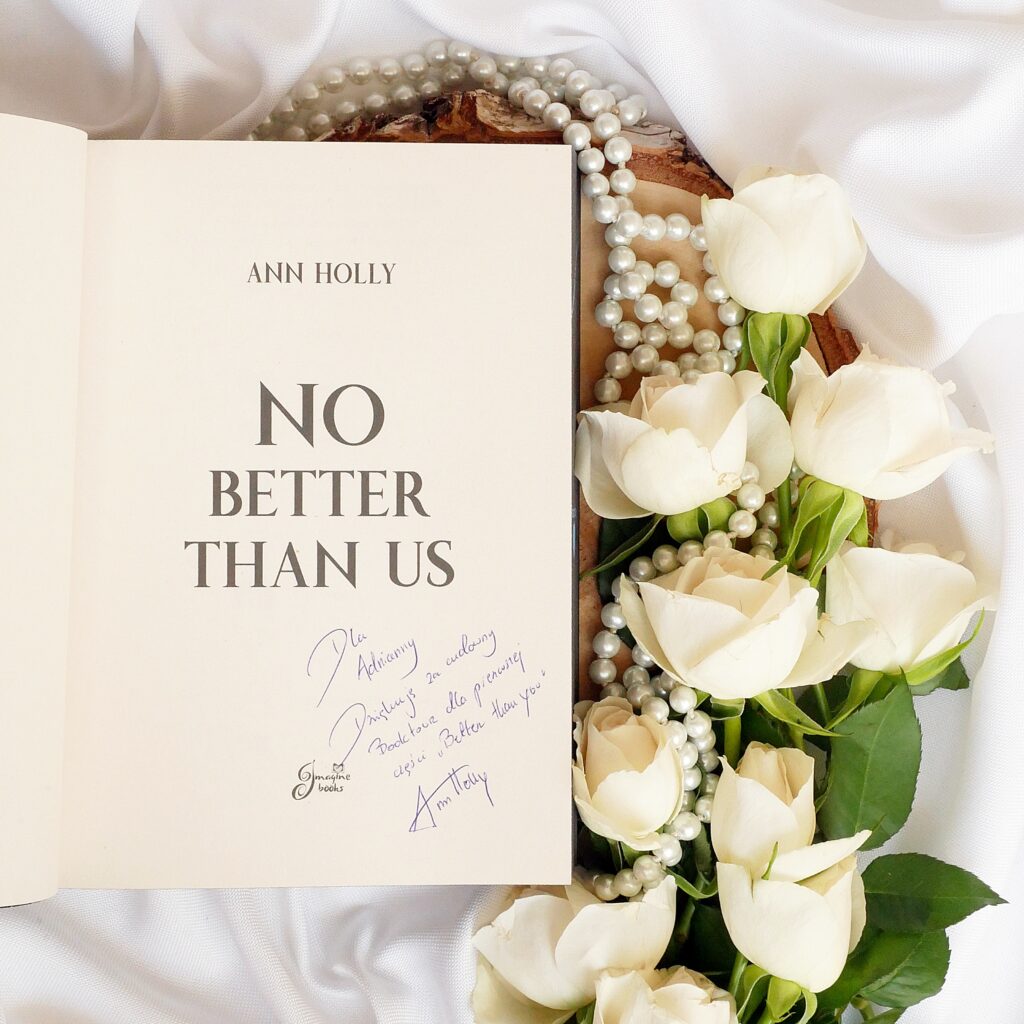 Strona tytułowa książki „No better than us” zdedykacją od wydawnictwa Imagine Books. Książka otoczona białymi różami i perłami.