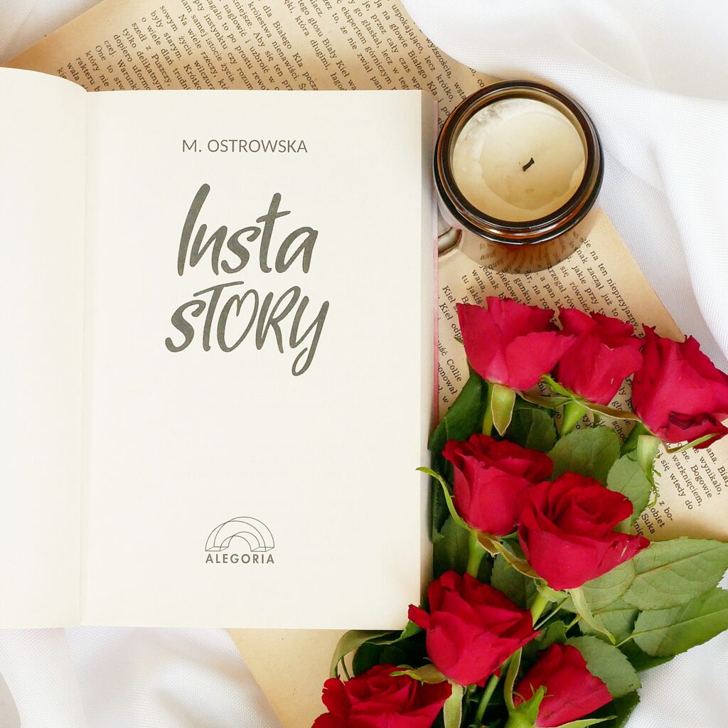 Strona tytułowa książki Magdalena Ostrowska-Dołęgowska „Insta story” z logo wydawnictwa Alegoria. Estetyczna kompozycja z czerwonymi różami ułożonymi na stronach starej książki oraz świecą w ciemnym szkle.