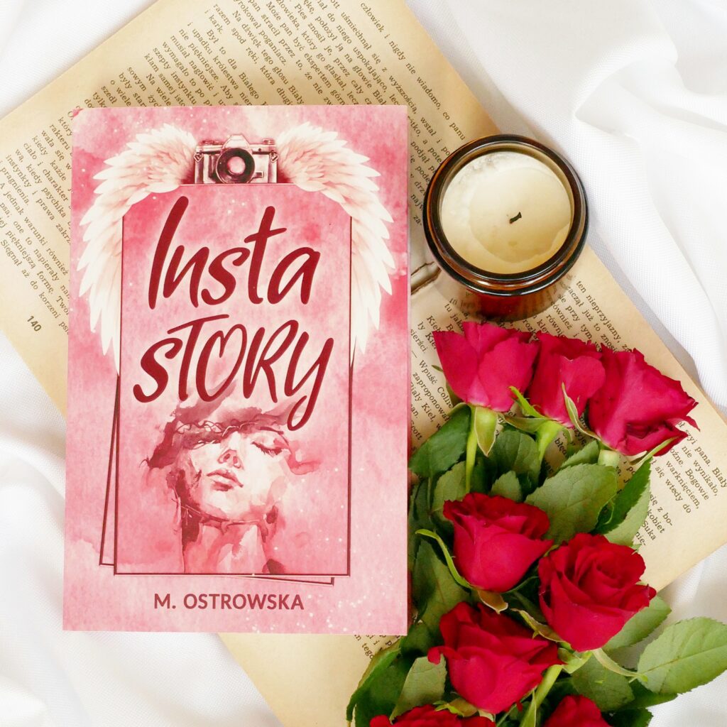 Magdalena Ostrowska-Dołęgowska „Insta story”. Okładka z grafiką kobiety i aparatu fotograficznego. Zdjęcie typu flat lay z czerwonymi różami, starymi stronami książki i świecą w ciemnym szkle.